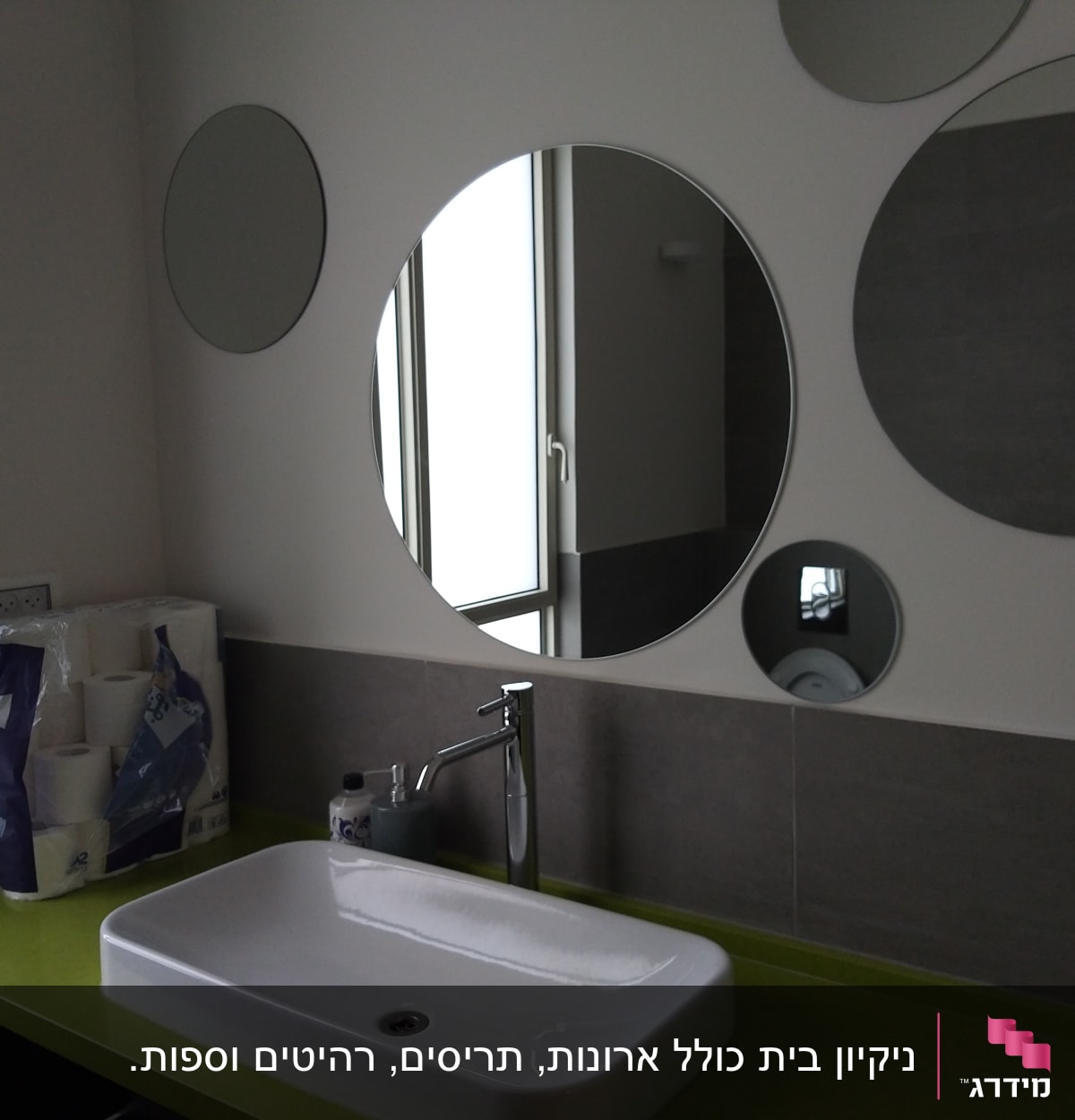 כיור עם ברז, מראה ונייר טואלט בחדר אמבטיה